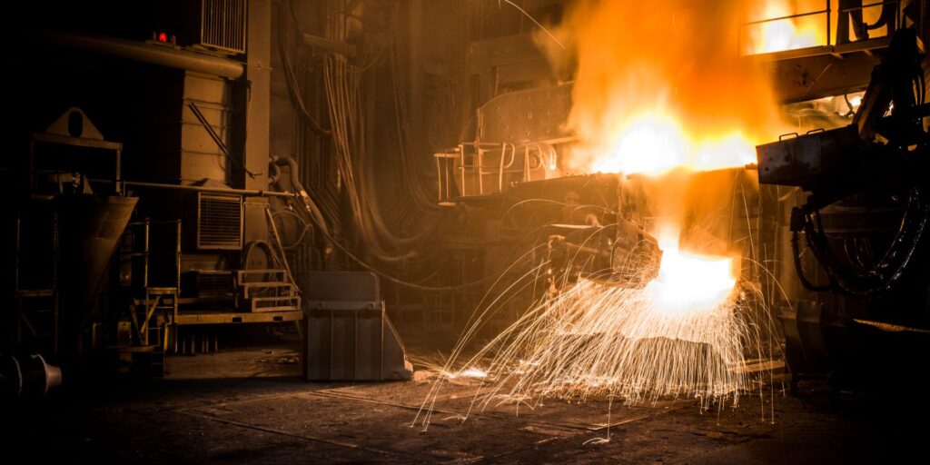 Electric arc furnace tapping molten steel in a dark melt shop