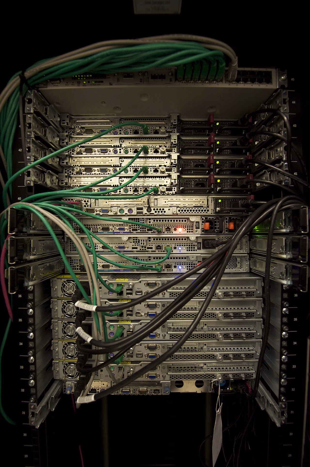 Physical server racks with mounted equipment and network cables.